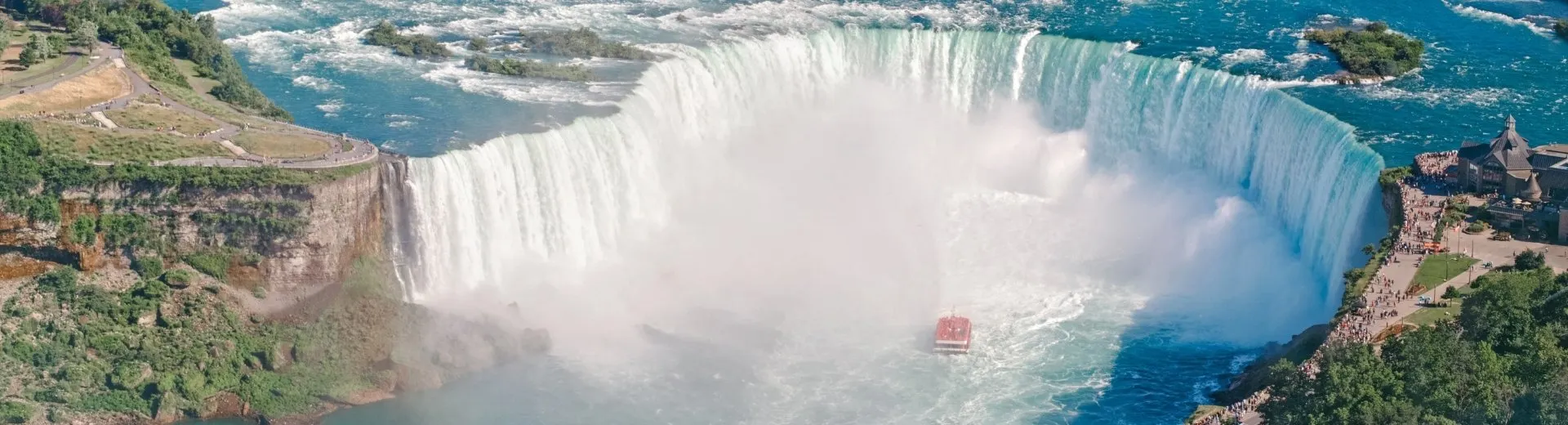 Luchtfoto van het landschap van de Niagara Falls tussen de Verenigde Staten en Canada. De hoefijzervormige Canadese waterval op een zonnige dag. Rondvaartboot bij deze beroemde toeristische trekpleister | de Jong Intra Vakanties