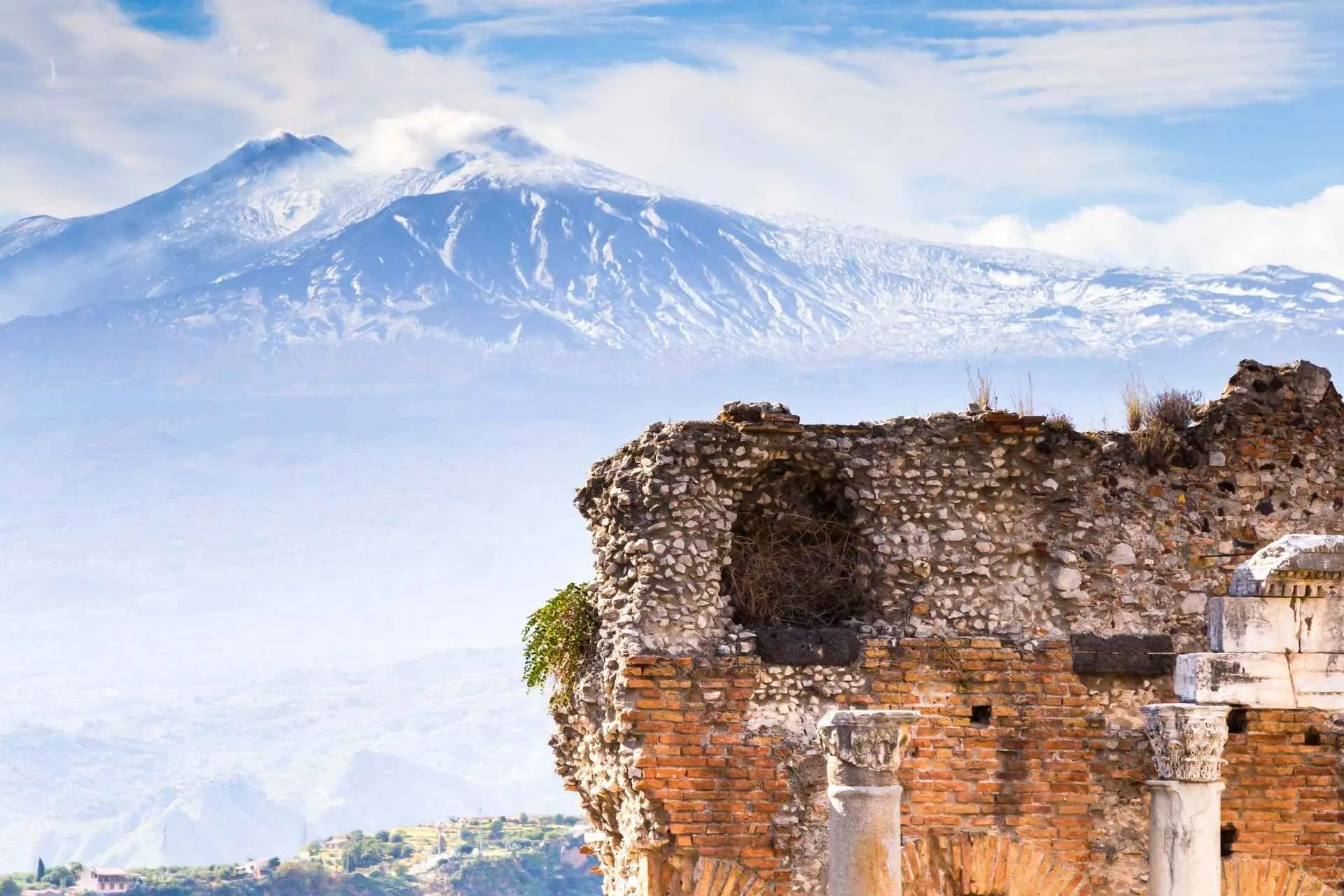 Uitzicht op de ruïnes en zuilen van het oude Griekse theater in Taormina en op de Etna vulkaan, Sicilië, Italië met de Jong Intra Vakanties